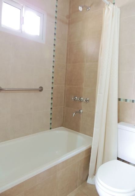 Ducha con bañera y cortina en el baño del duplex