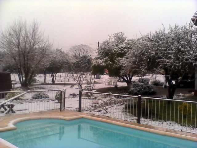 Amanecer nevado sobre la piscina del complejo