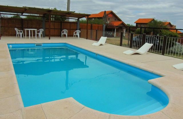 Reposeras junto a la piscina del duplex apart en Villa de Merlo