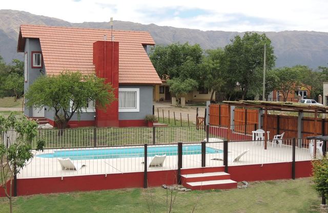 Vista de la piscina con los duplex de fondo en Villa de Merlo